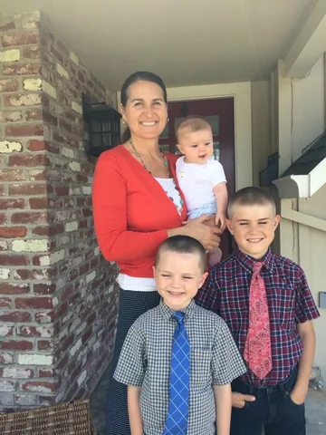 Amber holding her baby, with her two older sons in front of her